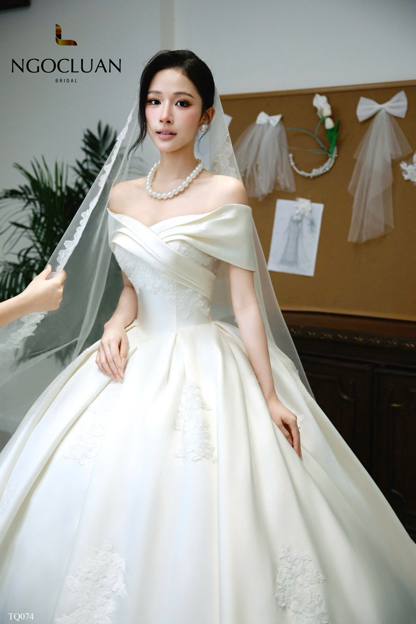 Khám phá thiết kế váy cưới trễ vai Classic Off-Shoulder Ball Gown từ NGOCLUAN BRIDAL. Chất liệu lụa satin, corset siết eo tôn dáng và ren thêu nổi tinh tế – khúc ca tình yêu dành riêng cho nàng.